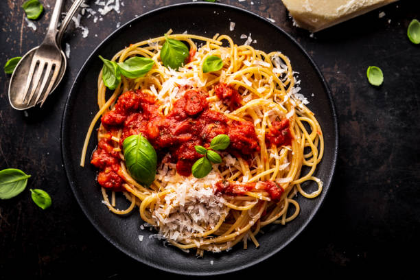 Delicious appetizing classic spaghetti pasta with tomato sauce, parmesan cheese and fresh herbs